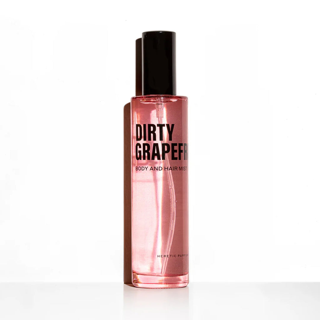 Dirty Grapefruit Body Mist Trio HERETIC PARFUM Flakon vor einer weißen Wand mit Schatten