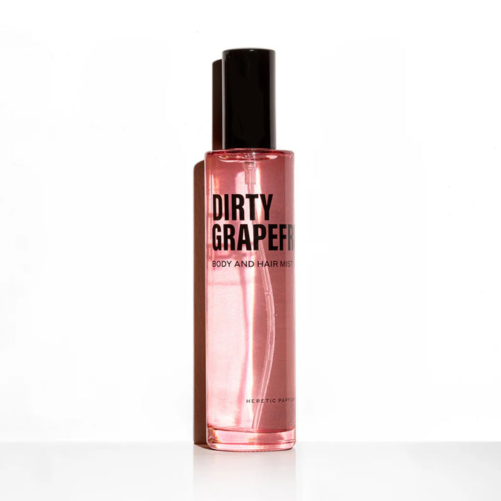 Dirty Grapefruit Body Mist Trio HERETIC PARFUM Flakon vor einer weißen Wand mit Schatten