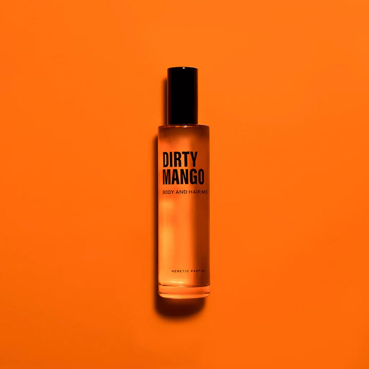 Dirty Mango Body Mist HERETIC PARFUM vor orangem Hintergrund