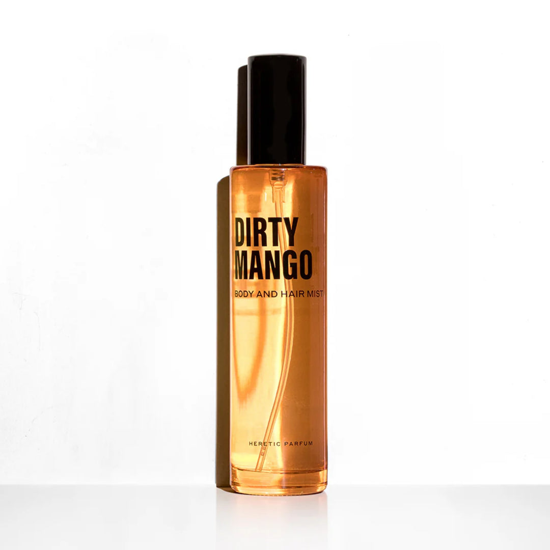 Dirty Mango Body Mist HERETIC PARFUM Flakon vor einer weißen Wand mit Schatten